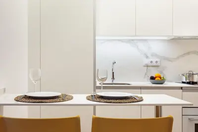 a kitchen with two white plates and wine glasses at Art House Travessera de Gràcia-2 in Barcelona