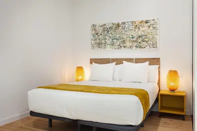 a bedroom with a bed with a painting on the wall at Art House Travessera de Gràcia-2 in Barcelona