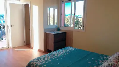 a bedroom with a sink and a bed and window at La Casa de Vacaciones in Terrassa