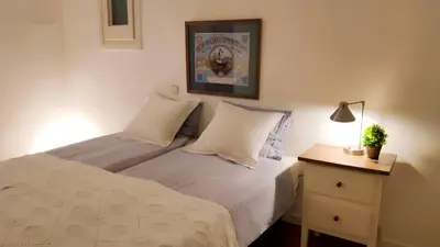 a bedroom with a bed with white sheets and a night stand at Rambla-Plça Catalunya 2BR monthly stays -R.H in Barcelona