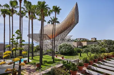 a view of a building with palm trees at Hotel Arts Barcelona in Barcelona