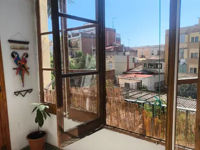 an open window with a view of a city at Habitación grande con balcón y mucha luz in Barcelona