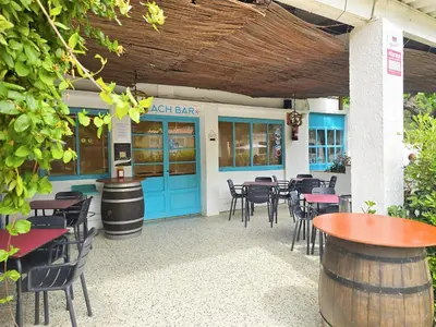 a restaurant with blue doors and tables and chairs at Costa Dorada Tiny Amaia in Canet de Mar