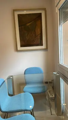 a waiting room with blue chairs and a painting at Apartamento cerca de Camp Nou in Hospitalet de Llobregat