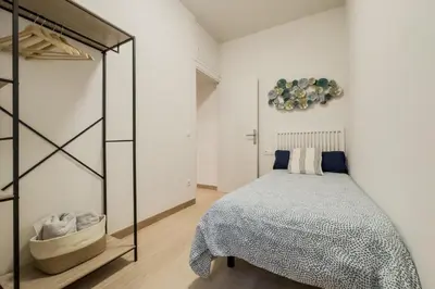 a bedroom with a bed and a glass closet at Apartamento cerca de Camp Nou in Hospitalet de Llobregat