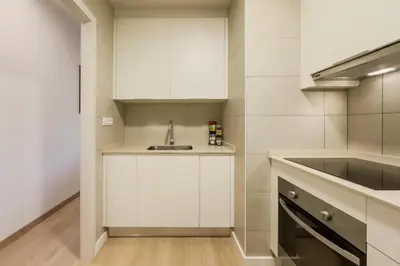 a kitchen with white cabinets and a sink at Apartamento cerca de Camp Nou in Hospitalet de Llobregat