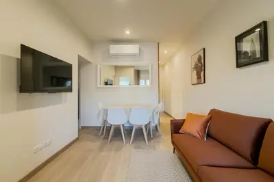 a living room with a couch and a table with chairs at Apartamento cerca de Camp Nou in Hospitalet de Llobregat