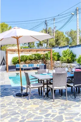 a table and chairs with an umbrella on a patio at Yasmine Casas Barcelona in Olivella