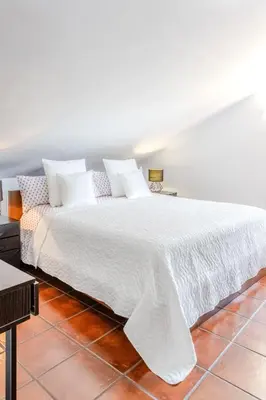 a large white bed with white sheets and pillows at Yasmine Casas Barcelona in Olivella