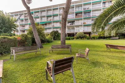 a group of park benches in front of a building at SeaSunSand Apartment in San Pol de Mar