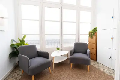 two chairs and a table in a room with windows at Apartamento de Lujo 7 Hab con balcón en Gran Vía -Grupos hasta 14 - 8min a pie Passeig Gràcia in Barcelona