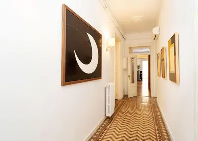 a hallway with white walls and a painting on the wall at Apartamento de Lujo 7 Hab con balcón en Gran Vía -Grupos hasta 14 - 8min a pie Passeig Gràcia in Barcelona
