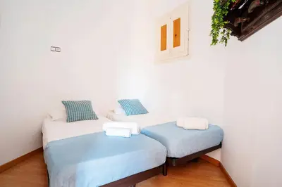 two twin beds in a room with a window at Apartamento de Lujo 7 Hab con balcón en Gran Vía -Grupos hasta 14 - 8min a pie Passeig Gràcia in Barcelona