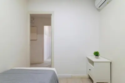 a bedroom with a bed and a dresser and a mirror at Furnished & Fully Equipped 2BR near the beach in Barcelona