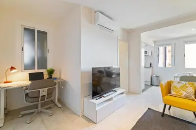 a living room with a desk and a computer and a tv at Furnished & Fully Equipped 2BR near the beach in Barcelona