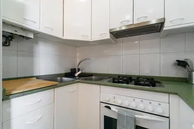 a white kitchen with a sink and a stove at Furnished & Fully Equipped 2BR near the beach in Barcelona
