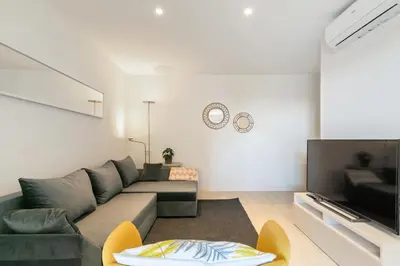 a living room with a couch and a tv at Furnished & Fully Equipped 2BR near the beach in Barcelona