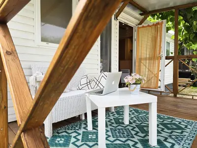 a porch with a table with a laptop on it at Bungalow in Canet de Mar near Scenic Beach in Canet de Mar
