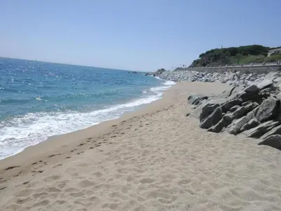 a sandy beach with rocks and the ocean at Bungalow in Canet de Mar near Scenic Beach in Canet de Mar