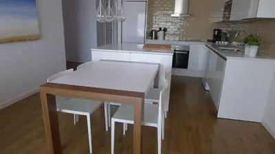 a kitchen with white cabinets and a table and chairs at Rustic good in Sitges