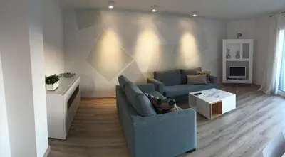 a living room with a blue couch and a table at Rustic good in Sitges