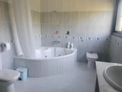 a white bathroom with a tub and a toilet at Large house surrounded by nature in Vilanova de la Roca