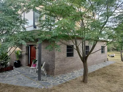 a brick house with a red door and a tree at Large house surrounded by nature in Vilanova de la Roca