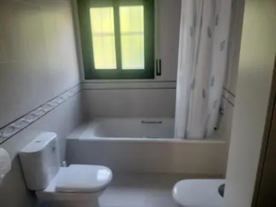 a bathroom with a toilet and a tub and a window at Large house surrounded by nature in Vilanova de la Roca