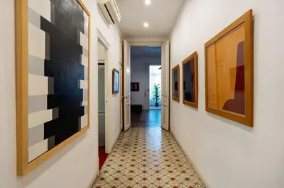 a hallway with paintings on the walls at Luxury Business Apartment Gran Vía - 2 rooms - Romantic Eixample - 8min Passeig Gràcia in Barcelona