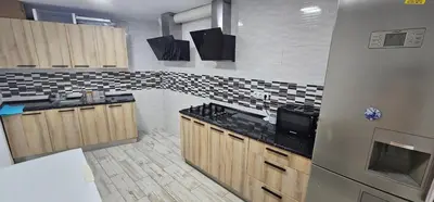 a kitchen with wooden cabinets and black counter tops at The Family Palace in Piera