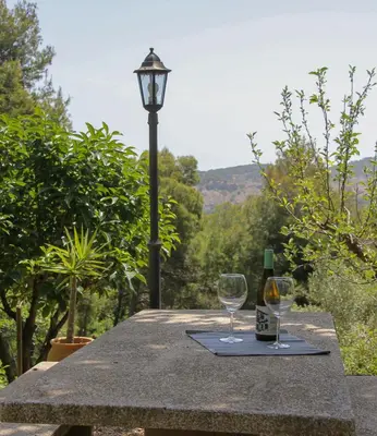 a table with two wine glasses and a street light at Refugio verde con encanto in Vallirana