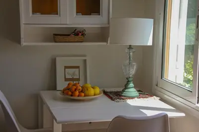 a table with a bowl of fruit and a lamp on it at Refugio verde con encanto in Vallirana