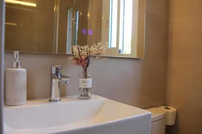 a bathroom with a sink and a vase with flowers in it at Refugio verde con encanto in Vallirana
