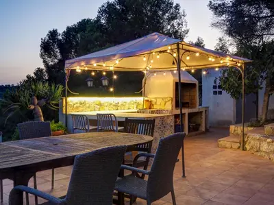 a patio with a table and chairs and a tent at Mikasi Hills by Hello Homes Sitges in Sant Pere de Ribes