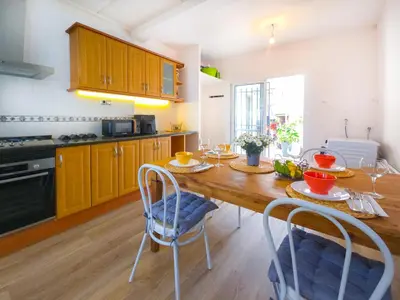 a kitchen with a wooden table with chairs and a dining room at Mikasi Hills by Hello Homes Sitges in Sant Pere de Ribes