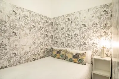 a bedroom with a bed with a floral wallpaper at Charm and Comfort in the Heart of Sant Antoni, Barcelona in Barcelona