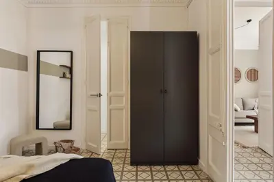 a bedroom with a bed and a table with a lamp at Loma - 3 bedrooms and office in Eixample Esquerra in Barcelona