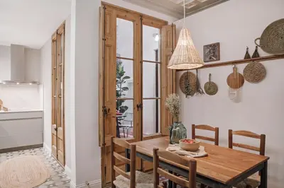a dining room with a table with chairs and a vase with flowers at Alajar - 3 bedrooms in St Pere Sta Caterina in Barcelona