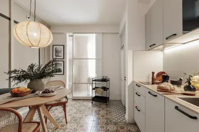 a kitchen with white cabinets and a table in a room at Tiqui - 1 bedroom and balcony in Vila de Gràcia in Barcelona
