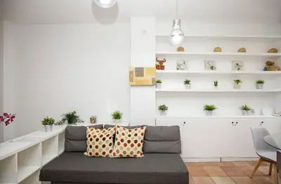 a living room with a couch and shelves with plants at Urban Gracia in Barcelona