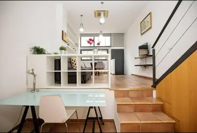 a living room with a glass table and a staircase at Urban Gracia in Barcelona