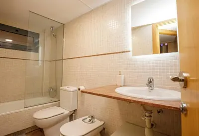 a bathroom with a toilet and a sink and a mirror at Urban Gracia in Barcelona