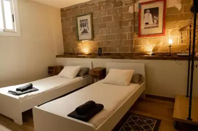 two beds in a room with a brick wall at Hermoso Apartamento cerca a Barcelona in Sant Adria de Besos