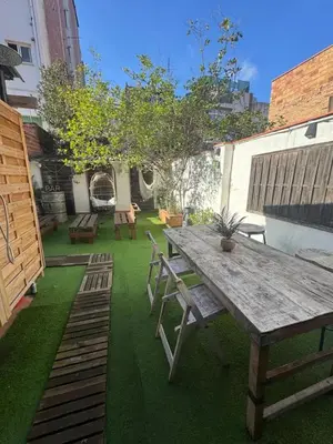 a patio with a wooden table and chairs at Hermoso Apartamento cerca a Barcelona in Sant Adria de Besos
