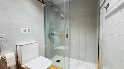 a bathroom with a toilet and a glass shower at Apartament rural in San Martín Sarroca