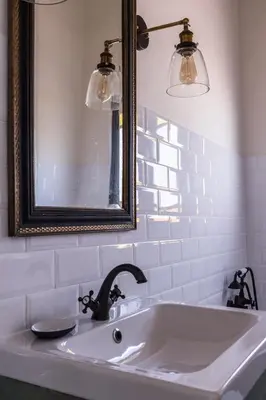 a bathroom with a sink with a mirror and lights at Traumhäuschen am Meer für 2, Barcelona in Vilassar de Mar