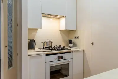 a kitchen with white cabinets and a stove top oven at Canela Homes BARCELONA GLÒRIES in Barcelona