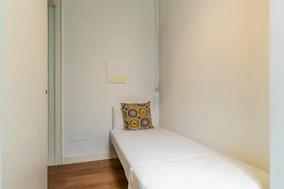 a white room with two beds in it at Canela Homes BARCELONA GLÒRIES in Barcelona