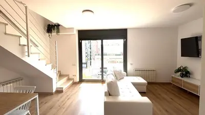 a living room with a white couch and a tv at Dúplex zona olimpica by Prestigi in Terrassa