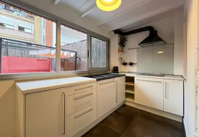 a kitchen with white cabinets and a window at Stay Unique Apartment Martínez de la Rosa in Barcelona